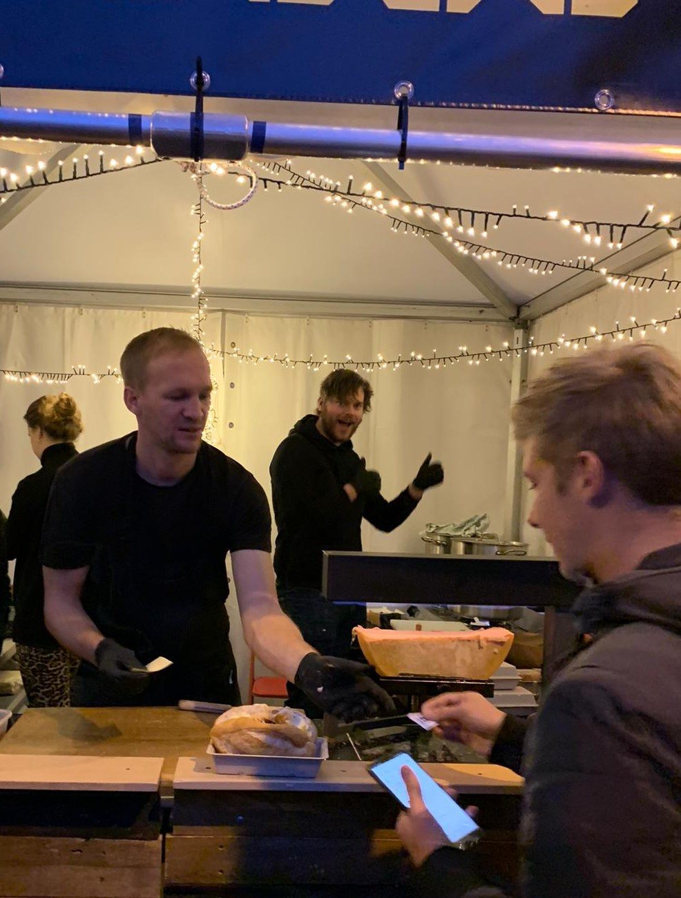 Serving raclette under fairy lights in the evening